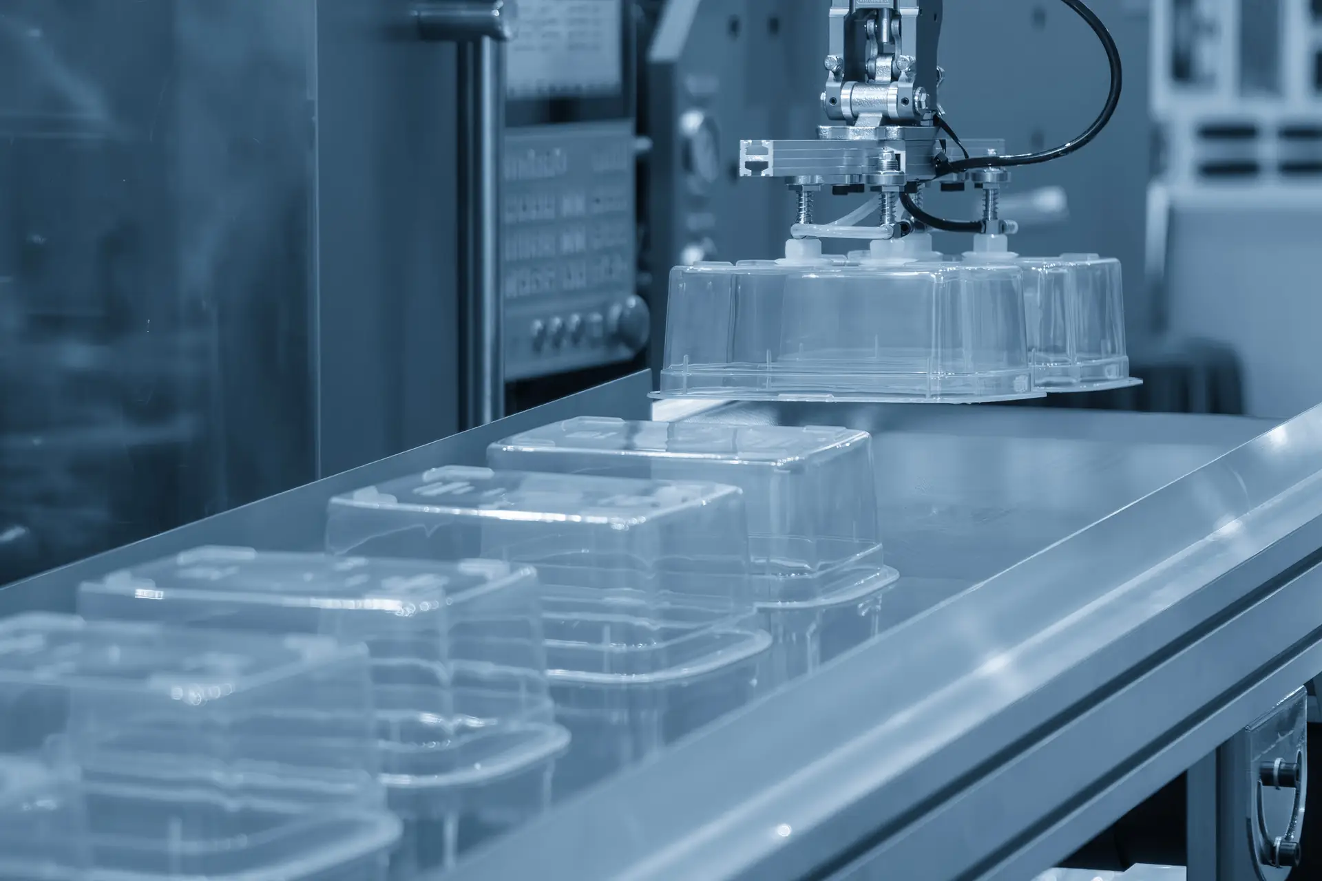The food container production process by automatic system from plastic injection mold machine. Close up scene material handling process the food container by robotic system from injection machine.
